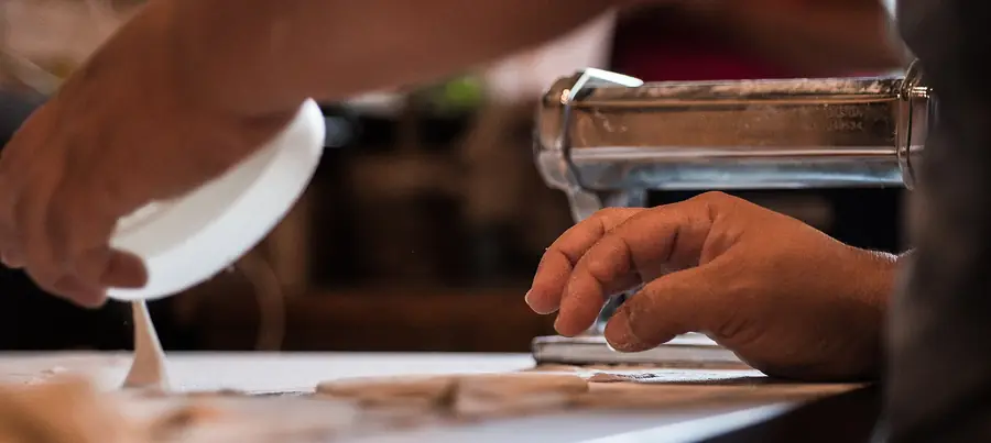 Fresh pizza dough being stretched by hand